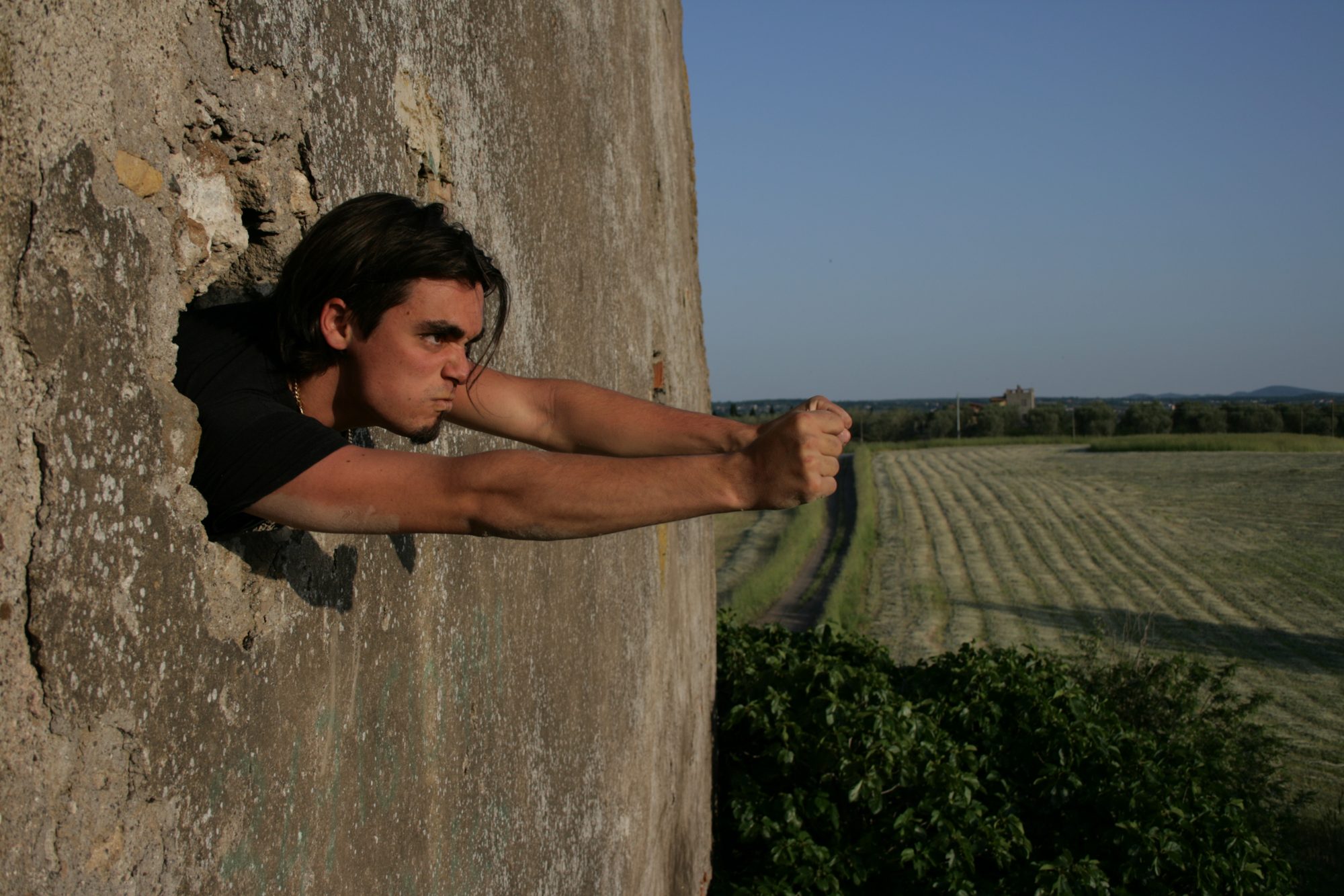Daniele che esce da un buco nel muro, verso i campi